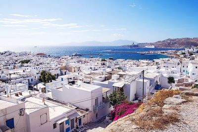 High angle view of houses and sea against sky on sunny day at mykonos