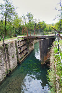 Footbridge over river against sky