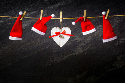 White heart and santa hats hanging on rope