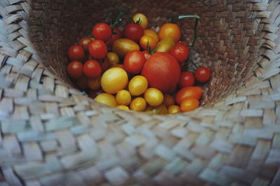 High angle view of cherry tomatoes in straw hat