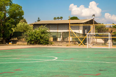 View of basketball court by building against sky