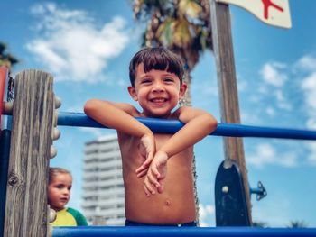 Portrait of happy boy leaning on railing