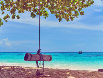 Lifeguard chair on beach against sky