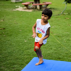 Asian smart kid doing yoga pose in the society park outdoor, children's yoga pose.