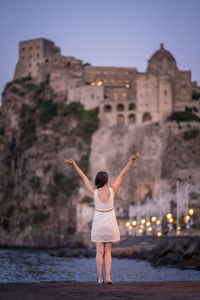 Full length rear view of woman standing in front of building