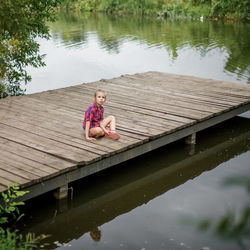 Portrait of woman on pier over lake