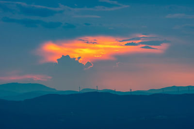 Scenic view of dramatic sky over silhouette landscape