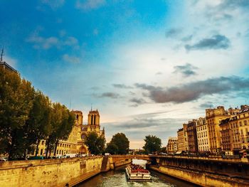 Buildings in city against cloudy sky