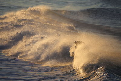 High angle view of sea wave at sunset