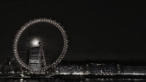 Illuminated london eye at night