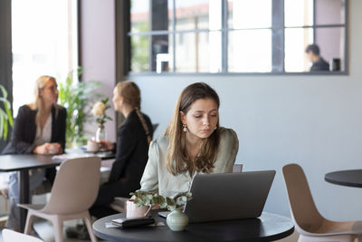 Businesswoman in cafe using laptop