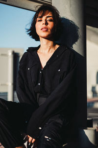 Portrait of young woman sitting outdoors