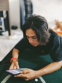 Man using mobile phone while sitting on table