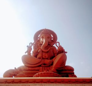 Low angle view of statue against temple against sky