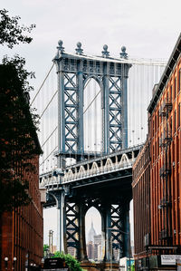 Manhattan bridge and buildings in city against clear sky