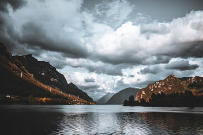 Scenic view of lake by mountains against sky