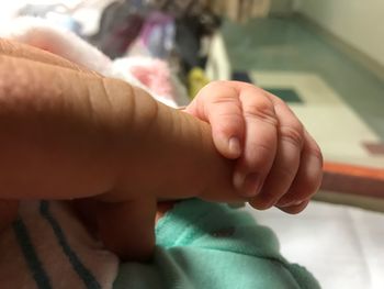 Close-up of hands holding baby at home