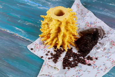 Close-up of yellow object with textile on wooden table