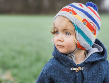 Cute girl in warm clothing looking away outdoors