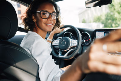 Portrait of young woman in car