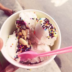 Close-up of hand holding ice cream in bowl 