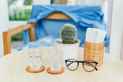 Close-up of glass and eyeglasses on table