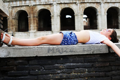 Girl lying on built structure
