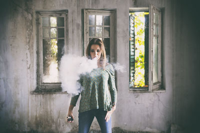 Portrait of young woman standing at home