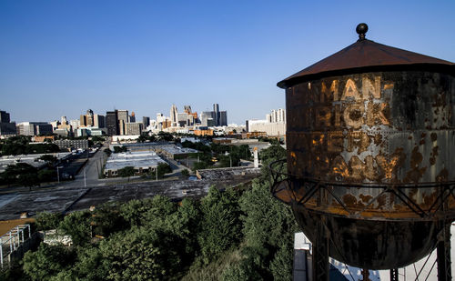 Water tower in city against clear sky