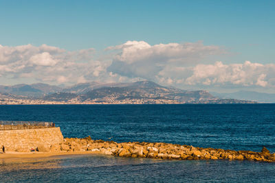 Scenic view of sea and mountains against sky