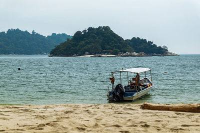 View of motorboat at beach against sky