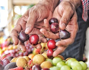 Close-up of hand holding cherries at farmers market 