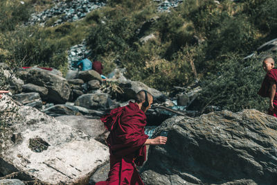 Monk listening to music while walking by rocks