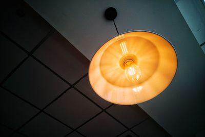 Low angle view of pendant light on ceiling in darkroom