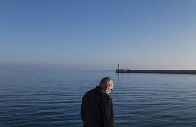 Adult man against sea and sky with lighthouse in background. almeria, spain