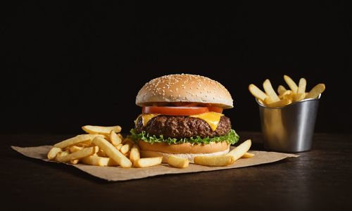 Close-up of burger on table against black background