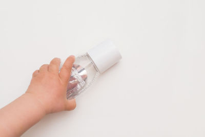 Close-up of hand holding camera over white background