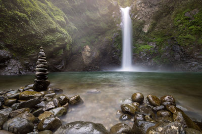 Scenic view of waterfall against mountain