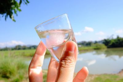 Close-up of hand holding a shot glass