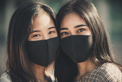 Close-up portrait of friends wearing mask