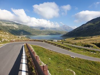 Scenic view of road by mountains against sky