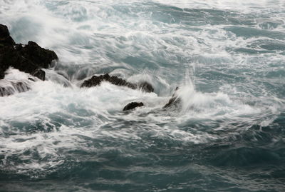 Waves crashing on rocks in sea