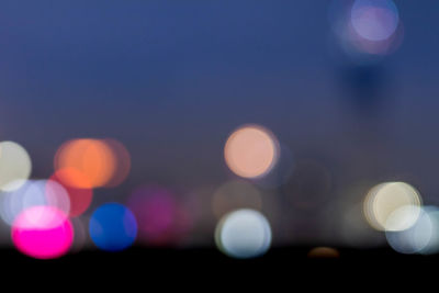 Defocused image of illuminated lights in city at night