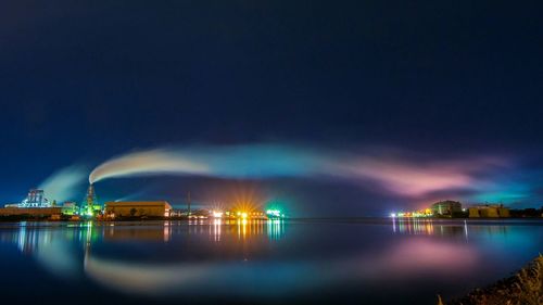 View of illuminated bridge over river at night