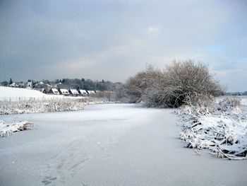 Scenic view of snow covered land against sky