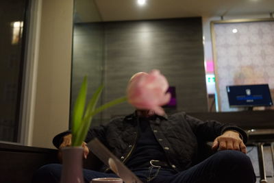 Pink rose in front of man sitting in office