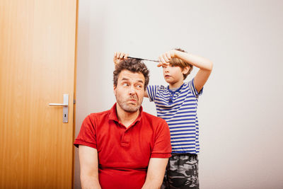 Portrait of young man standing against wall