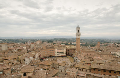 Buildings in city against cloudy sky