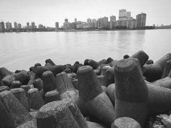 Scenic view of river by cityscape against sky