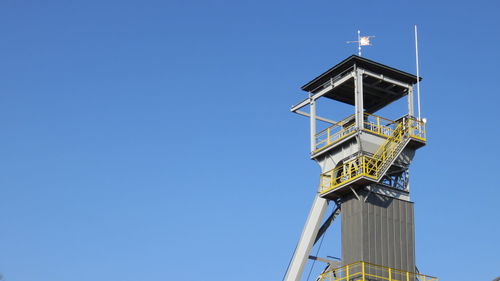 Low angle view of headframe at wieliczka salt mine against clear blue sky